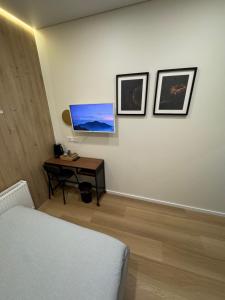 a bedroom with a bed and a desk with a television at 12 New Airport Apartment in Pakopi +6 photos