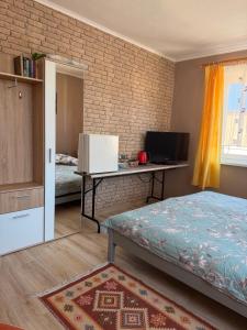 a bedroom with a bed and a desk and a television at Dom wczasowy Max in Darłowo
