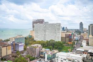 Un horizonte de ciudad con edificios y el océano. en 芭提雅Edge极致高端景观房-海景城景巨大顶楼泳池-健身房按摩房乒乓球室花园餐厅, en Pattaya central