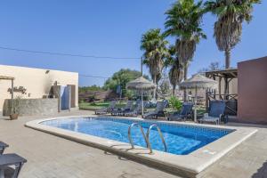 Una piscina con sillas y sombrillas al lado de una casa. en Casa Mirador De Cádiz, en Conil de la Frontera
