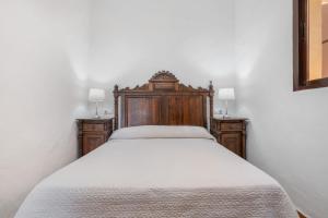 1 cama con cabecero de madera y 2 mesitas de noche en Casa Mirador De Cádiz, en Conil de la Frontera 18 fotos más