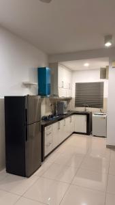 a large kitchen with stainless steel appliances and white cabinets at Cozy SK 1 Room 3 Pax UPM MRT in Seri Kembangan