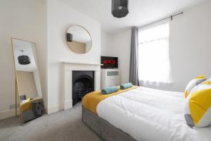 een slaapkamer met een groot bed en een open haard bij Chill in Gill Comfy House, Free Parking x 1 in Gillingham