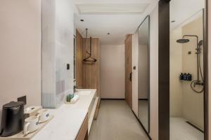 a bathroom with two sinks and a mirror at Holiday Inn Express Shanghai Changyang Road by IHG in Shanghai +85 photos