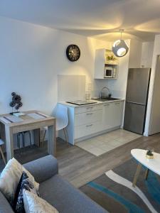 a kitchen and living room with a couch and a table at Appartement cosy proche Disneyland in Serris