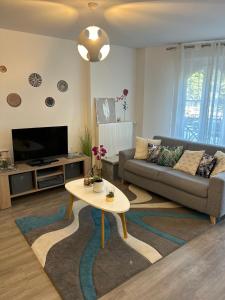a living room with a couch and a table at Appartement cosy proche Disneyland in Serris