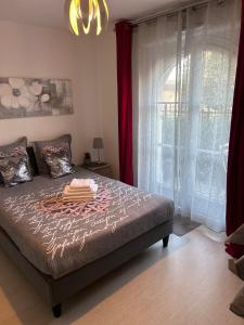 a bedroom with a bed with red curtains and a window at Appartement cosy proche Disneyland in Serris
