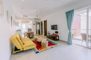 ein Wohnzimmer mit einem gelben Stuhl und einem Tisch in der Unterkunft Humble Pineapple by Da Alohas in Calangute + 14 Fotos