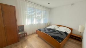 a bedroom with a bed and a window and a chair at MILITARY Guest Inn in Drawsko Pomorskie