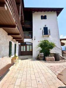 a white building with a door and a plant at Maso Sasso - La Locanda di Putipù in Villa Lagarina