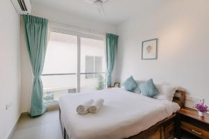 ein Schlafzimmer mit einem Bett, auf dem zwei Handtücher liegen in der Unterkunft Humble Pineapple by Da Alohas in Calangute