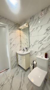 a white bathroom with a toilet and a sink at MILITARY Guest Inn in Drawsko Pomorskie