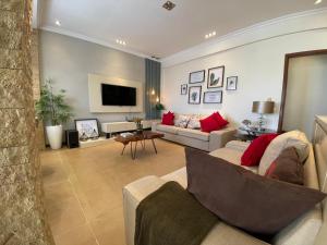 a living room with two couches and a tv at The Fifth in Luanda