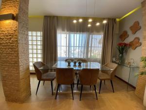 a dining room with a glass table and chairs at The Fifth in Luanda