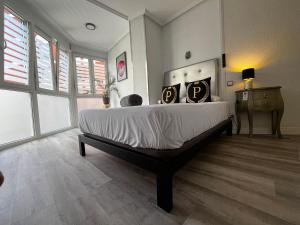 Un dormitorio con una cama grande con dos almohadas encima. en Puerto Principe PENSIÓN, en Santander