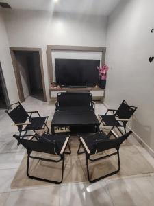 een kamer met stoelen, een tafel en een tv bij Melody Homestay in Kuala Kedah +12 foto's