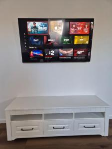 - un centre de divertissement blanc avec une télévision murale dans l'établissement Apartmán By One, à Banská Štiavnica