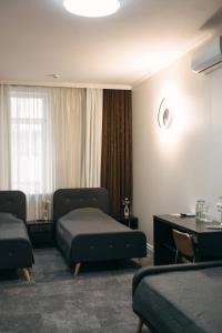 a hotel room with two beds and a table at Summit Villa in Chişinău