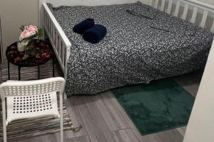 a bedroom with a bed with blue pillows and a chair at Studio Sleeps 2 next to Acton Central in London