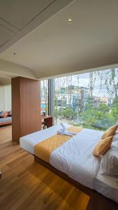 a large bed in a room with a large window at Hotel Amigos in Bangalore