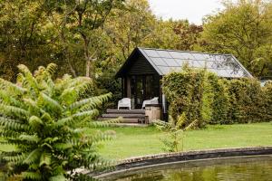a black cabin with a glass roof in a garden at Parc Boulée in Ven-Zelderheide