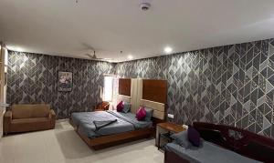 a living room with a bed and a couch at FabHotel Ayaansh in Hyderabad