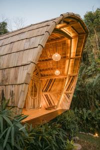 a large wooden building with a wooden roof at Arcana Hideout - The Aesthetic Bamboo Escape in Selat