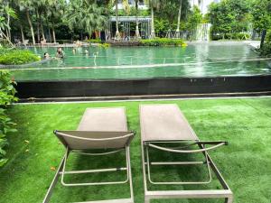 two chairs sitting on the grass in front of a fountain at Sky View Agile Residence Bukit Bintang KL in Kuala Lumpur