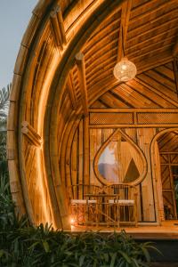 a large wooden building with a table in it at Arcana Hideout - The Aesthetic Bamboo Escape in Selat