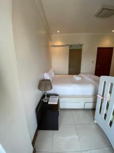 a bedroom with a bed and a lamp on a table at The Fifth in Luanda