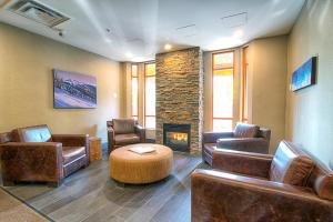 a waiting room with leather furniture and a fireplace at Whistler Town Plaza by Latour Hotels and Resorts in Whistler