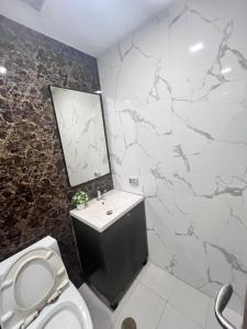 a bathroom with a toilet and a sink and a mirror at Arcadia Beach Continental By Palmera Pattaya in Pattaya South +16 photos