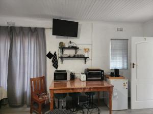 a kitchen with a wooden table with a microwave and a counter top at Groenewald's Haven in Nelspruit