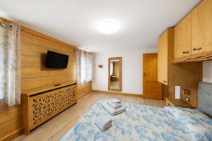 a bedroom with a bed and a tv on a wall at Appartamento Padola 72 in Padola