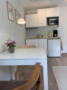 a kitchen and dining room with a white table and chairs at Rotkehlchen Ferienwohnung in Herborn