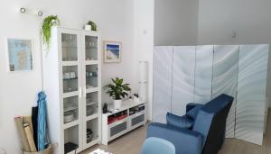 a living room with a blue chair and a white cabinet at La Mandronia Loft in Alghero