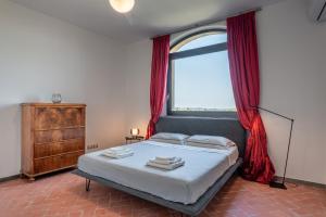 a bedroom with a bed with red curtains and a window at Terrazza su San Miniato con garage in San Miniato