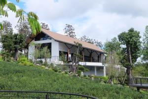 a house on a hill with a garden at PASSA ผัสสะ Tea Plantation @Mae On in Ban Huai Kaeo