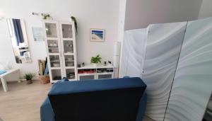 a living room with a blue chair and a table at La Mandronia Loft in Alghero
