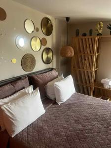a bedroom with a bed with pillows and mirrors on the wall at Exclusive Del Mare Hotel in Sidari