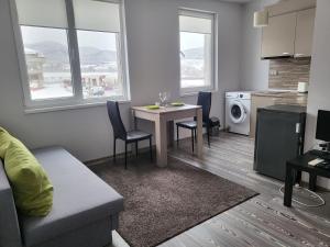 a living room with a couch and a table with chairs at Апартамент Димана in Hisarya