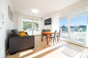 a living room with a couch and a table with chairs at Apartments Break with pool in Novalja