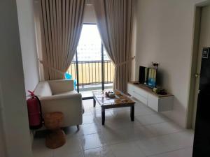 a living room with a chair and a table and a window at Iskandar SmartStay in Kampong Bota Road