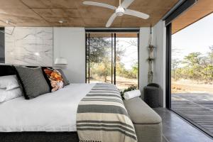 a bedroom with a bed and a ceiling fan at Buffelshuis Safari Camp in Golders Green +79 photos
