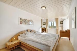 une chambre avec un grand lit blanc et une chaise dans l'établissement Ferienwohnung Haus Amann, à Mitten