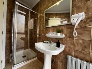 a bathroom with a sink and a shower at Puerto Principe PENSIÓN in Santander