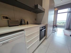 a kitchen with white cabinets and a counter top at The Capital Trilogy Hotel in Pretoria
