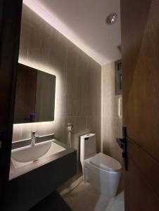 アル・カルジにあるشقق ضيافة البرجの洗面台とトイレ付きのバスルーム +4枚の写真