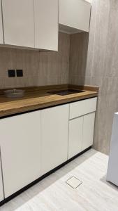 アル・カルジにあるشقق ضيافة البرجの白いキャビネットとカウンタートップを備えたキッチン