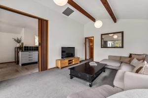 a living room with a couch and a coffee table at Tranquil Hideaway - Lake Okareka Holiday Home in Lake Tarawera